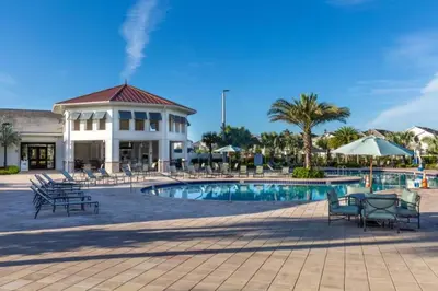 a resort with a pool and chairs and a building at 2 Bedrooms 2 Bathrooms Storey Lake 3151-404 in Kissimmee