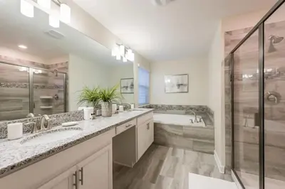 a bathroom with two sinks and a shower and a tub at Refúgio de Luxo 6 quartos c/ piscina aquecida in Kissimmee