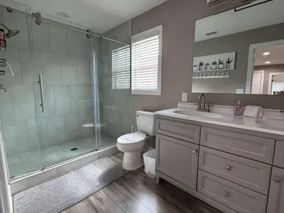 a bathroom with a shower and a toilet and a sink at Peace in the Garden - Home in Winter Garden in Orlando