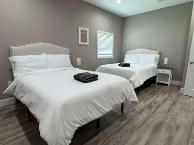 a bedroom with two beds with white sheets at Peace in the Garden - Home in Winter Garden in Orlando