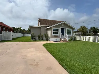 a small house with a white fence in a yard at Peace in the Garden - Home in Winter Garden in Orlando