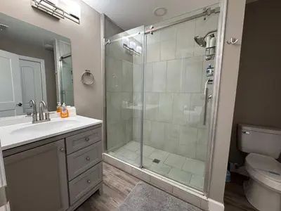a bathroom with a shower with a sink and a toilet at Peace in the Garden - Home in Winter Garden in Orlando