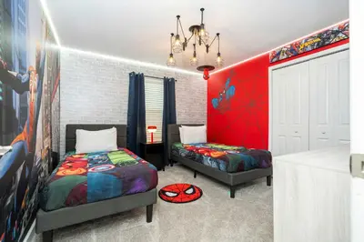 a bedroom with two beds and a red wall at Private Pool - Themed Rooms - Near Disney 4239 in Kissimmee