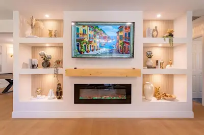 a living room with a tv above a fireplace at Spacious Modern Japandi Retreat - Winter Park in Orlando