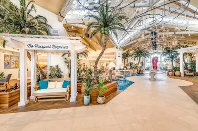 a lobby with palm trees in a building at Paradise Breeze Cottage By Shine Villas Margaritaville Resort Orlando in Orlando