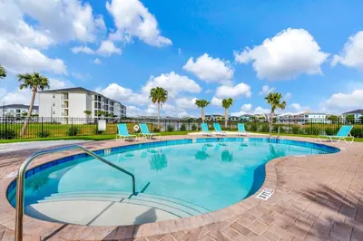 a large swimming pool with chairs and palm trees at Paradise Breeze Cottage By Shine Villas Margaritaville Resort Orlando in Orlando