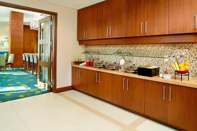 a kitchen with wooden cabinets and a dining room at Residence Inn by Marriott Orlando Lake Nona in Orlando