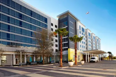 a large building with palm trees in front of it at Residence Inn by Marriott Orlando Lake Nona in Orlando