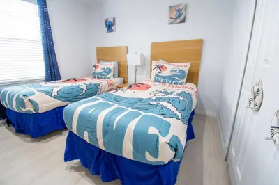two beds in a bedroom with blue and white at NEW - Townhome on amazing resort - private hot tub in Kissimmee
