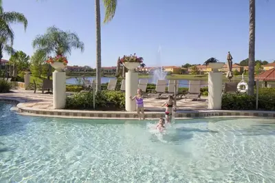 two children playing in a swimming pool at a resort at NEW - Townhome on amazing resort - private hot tub in Kissimmee