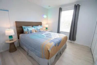 a bedroom with a large bed and a window at NEW - Townhome on amazing resort - private hot tub in Kissimmee