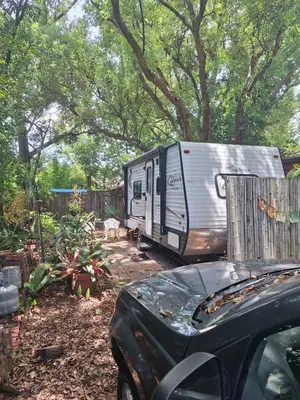 a car parked in a yard with a trailer at Tiny Trailer happy hole in the wall in Orlando
