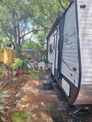 a trailer parked in a yard next to a fence at Tiny Trailer happy hole in the wall in Orlando