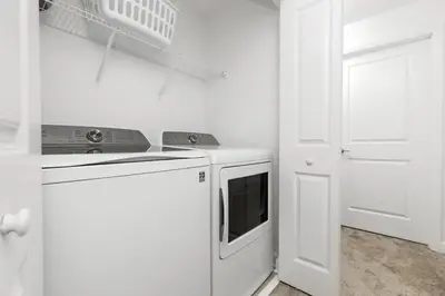 a white kitchen with a stove and a dishwasher at Resort completo a minutos da Disney e outlets in Kissimmee