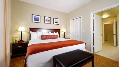 a bedroom with a large bed with a red blanket at Calypso Cay Vacation Villas in Kissimmee