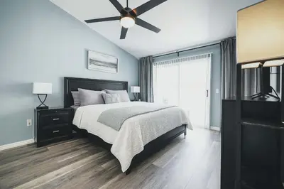 a bedroom with a bed and a ceiling fan at 3BD Townhome with Pool 12mi to Disney and Universal in Kissimmee