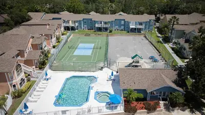 an aerial view of a house with a tennis court at 3BD Townhome with Pool 12mi to Disney and Universal in Kissimmee