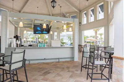 a restaurant with a bar with black chairs and tables at Go08 - STOREY LAKE in Kissimmee