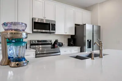 a kitchen with white cabinets and a blender on a counter at Bright And Beachy Villa Near Disney With Margaritaville Resort And Island H20 Waterpark Access - 3012Cs in Orlando
