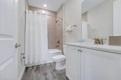 a white bathroom with a toilet and a sink at Bright And Beachy Villa Near Disney With Margaritaville Resort And Island H20 Waterpark Access - 3012Cs in Orlando