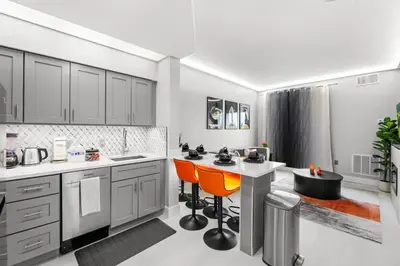 a kitchen with white counters and orange chairs at 1BR Suite Prime Orlando Location in Orlando
