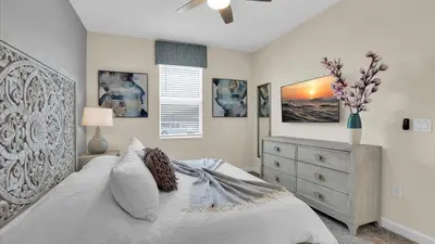 a bedroom with a white bed and a dresser at Parfect Paradise in Orlando