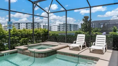 a swimming pool with two chairs and a building at Storey Lake Villa in Kissimmee