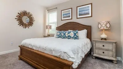 a bedroom with a bed and a nightstand and a mirror at Storey Lake Retreat in Kissimmee