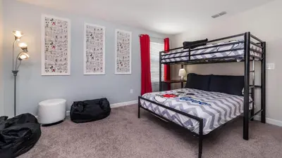 a bedroom with a bunk bed and red curtains at Storey Lake Retreat in Kissimmee