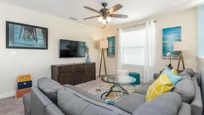 a living room with two couches and a tv at Storey Lake Retreat in Kissimmee