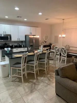 a kitchen with a table and chairs and a kitchen with at Resort 4 Br 3 Ba Private Pool Home & Lake View near Disney & Universal in Kissimmee