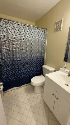 a bathroom with a toilet and a shower curtain at G7 Private Room with Smart TV Near Everything in Orlando