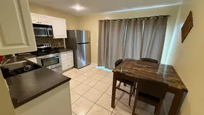a small kitchen with a table and a refrigerator at G7 Private Room with Smart TV Near Everything in Orlando