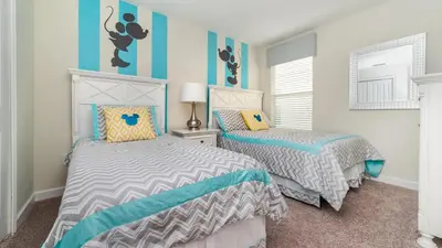 a bedroom with two beds and blue and white walls at The Sunshine Villa in Kissimmee