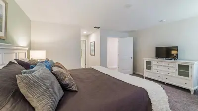 a bedroom with a large bed and a television at The Sunshine Villa in Kissimmee