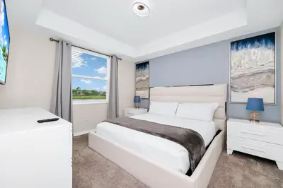 a white bedroom with a bed and a window at 2BR Family Condo Near Disney, Universal and More in Kissimmee