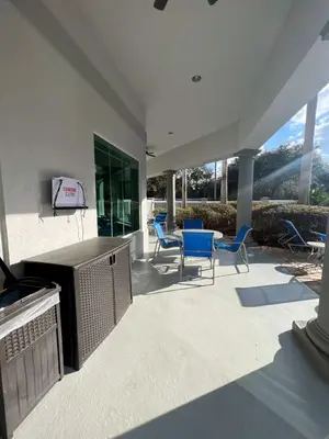 a patio with chairs and a table and a television at Aqua Condo-Free Shuttle-Disney-Universal EPIC in Orlando
