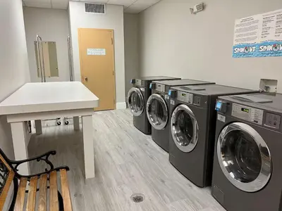 a laundry room with three washing machines and a counter at Condo-Free Shuttle-Disney-Universal Epic in Orlando