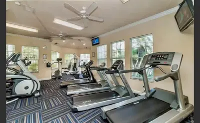 a gym with several treadmills and cardio machines at Apartment near Disney & UniversalEpic in Orlando