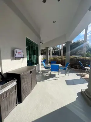 a patio with chairs and a television and a table at Comfy Condo near Disney-Free Shuttle to Parks in Orlando
