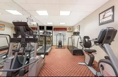 a gym with treadmills and ellipticals in a room at Comfy Condo near Disney-Free Shuttle to Parks in Orlando