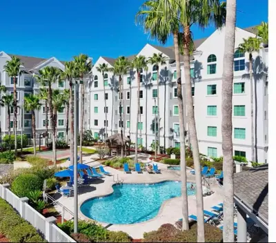 a view of a hotel with a pool and palm trees at Condo near Disney-free shuttle to all theme parks in Orlando