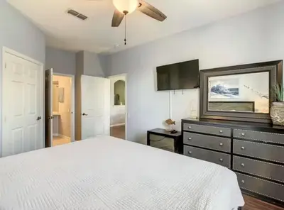 a bedroom with a white bed and a flat screen tv at Condo Disney Universal Epic Pool in Kissimmee