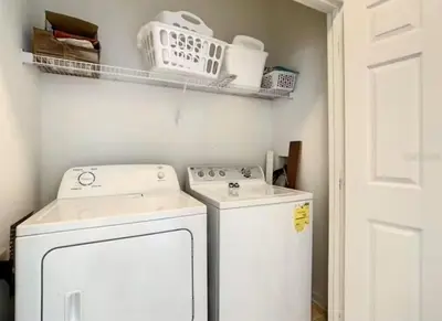 a small laundry room with a washer and dryer at Condo Disney Universal Epic Pool in Kissimmee