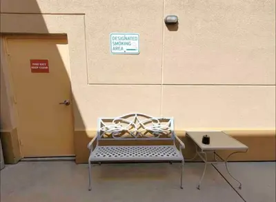 a bench with a sign on it next to a door at Cozy Condo near Disney World with Shuttle to parks in Orlando