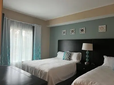a bedroom with two beds and a window at Cozy Condo near Disney World with Shuttle to parks in Orlando