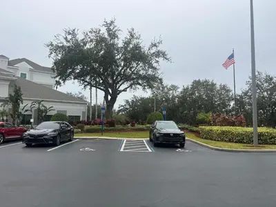 two cars parked in a parking lot in front of a house at Inspiration condo near Disney with free shuttle in Orlando