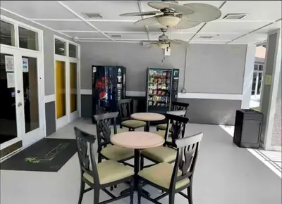 a dining room with tables and chairs and a whiteboard at Condo 2 Queen beds-Disney-Universal in Orlando