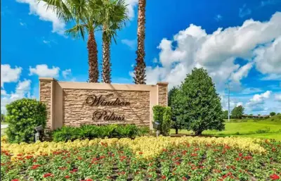 a sign in front of a building with palm trees at Apartment Disney Universal Epic in Orlando
