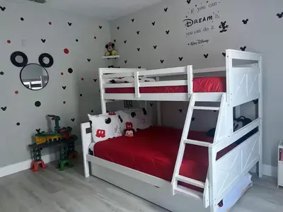 a bedroom with a white bunk bed with a red mattress at Amazing Condo near Disney in Kissimmee